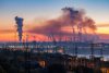 Industrial landscape of plant pipes producing toxic smoke with air pollution in the sky on sunset, hydroelectric dam and high voltage towers, Zaporizhzhia, Ukraine, EU