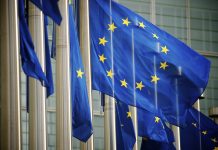 "EU flags fly in a row in front of the European Commission building in Brussels, Belgium"