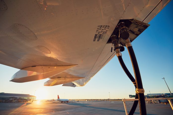 Amazing sunset at the airport. Refueling of the airplane before flight.