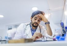 doctor looking stressed over technology