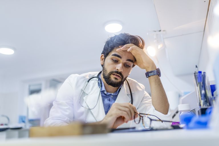 doctor looking stressed over technology