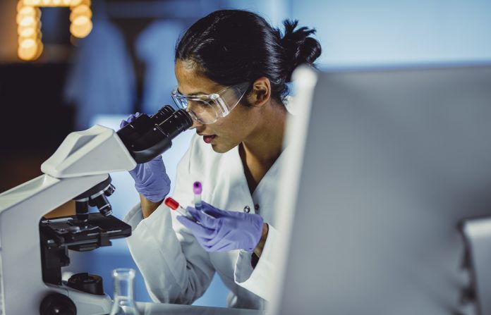 Young Scientist Looking Through a Microscope