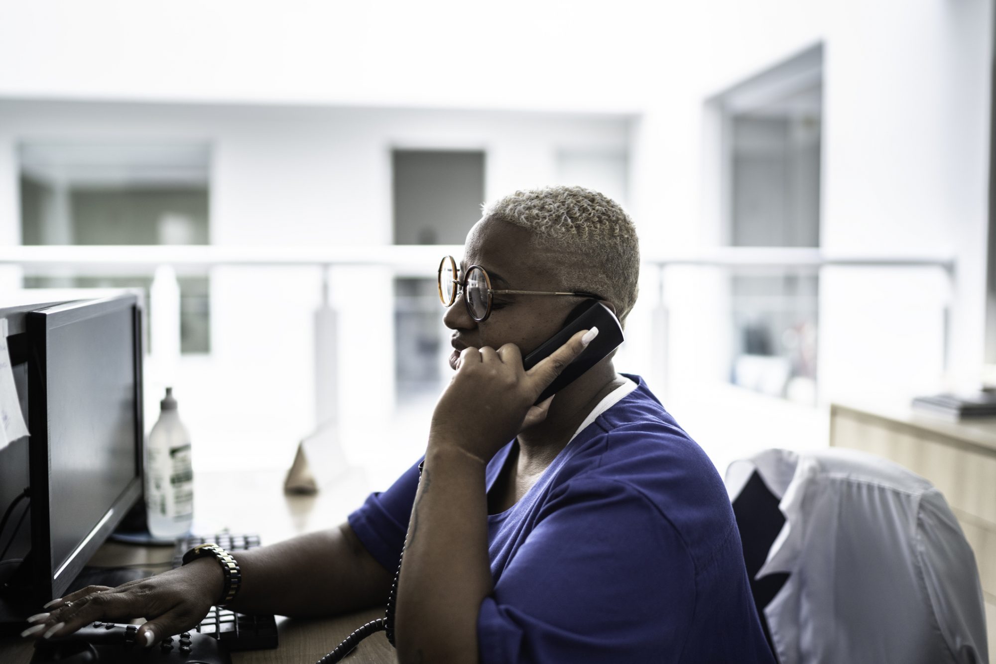 Secretary talking on telephone at hospital reception