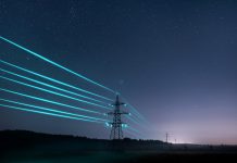 Electricity transmission towers with glowing wires against the starry sky