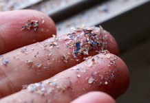 Close up side shot of microplastics lay on people hand.Concept of water pollution and global warming. Climate change idea.