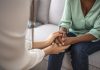 African psychologist hold hands of girl patient, close up. Teenage overcome break up, unrequited love. Abortion decision. Psychological therapy, survive personal crisis, individual counselling concept
