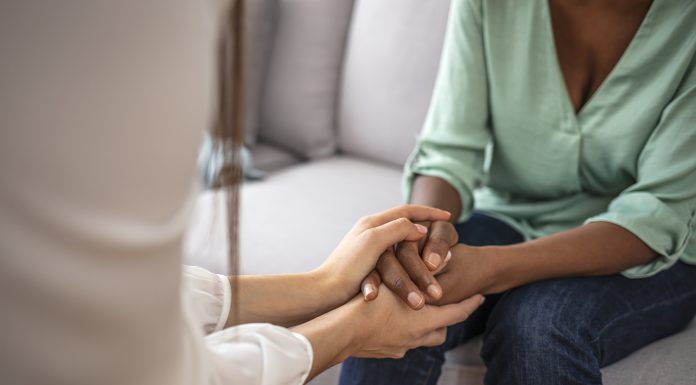 African psychologist hold hands of girl patient, close up. Teenage overcome break up, unrequited love. Abortion decision. Psychological therapy, survive personal crisis, individual counselling concept