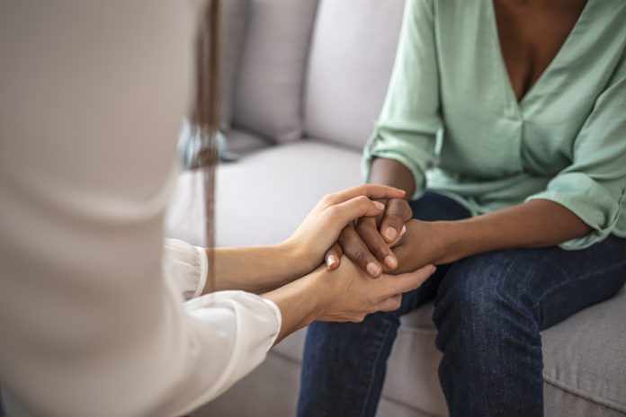 African psychologist hold hands of girl patient, close up. Teenage overcome break up, unrequited love. Abortion decision. Psychological therapy, survive personal crisis, individual counselling concept