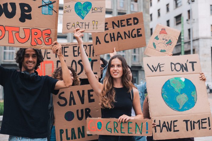 Enthusiastic young people making strike on the street, fighting for saving environment and protesting for climate changes.