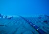 Underwater fiber-optic cable on ocean floor.