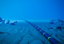 Underwater fiber-optic cable on ocean floor.