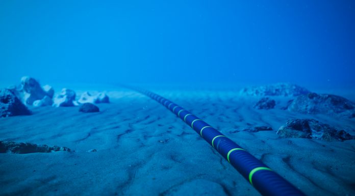 Underwater fiber-optic cable on ocean floor.