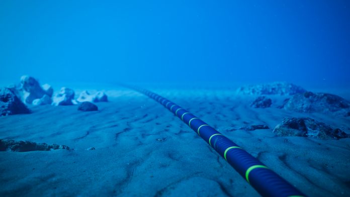 Underwater fiber-optic cable on ocean floor.