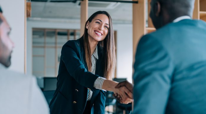 Business people shaking hands in the office. Group of business persons in business meeting. Three entrepreneurs on meeting in board room. Corporate business team on meeting in modern office. Female manager discussing new project with her colleagues. Company owner on a meeting with two of her employees in her office.