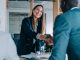 Business people shaking hands in the office. Group of business persons in business meeting. Three entrepreneurs on meeting in board room. Corporate business team on meeting in modern office. Female manager discussing new project with her colleagues. Company owner on a meeting with two of her employees in her office.