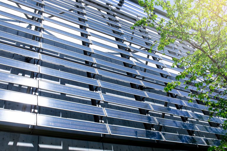 Solar Panel wall on Building with tree leaves