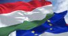 Detail of the national flag of Hungary waving in the wind with blurred european union flag in the background on a clear day. Democracy and politics. European country. Selective focus.