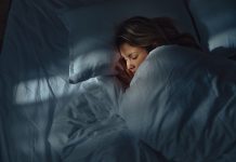 High angle view of a woman taking a nap in her bed at night. Photographed in medium format.