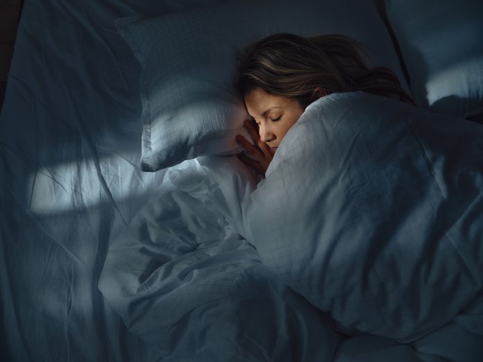 High angle view of a woman taking a nap in her bed at night. Photographed in medium format.