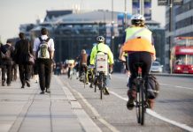 City workers walking and cycling over Waterloo Bridge at the end of the working day. Crash zoom effect done in camera.