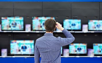 man looking at tvs when shopping