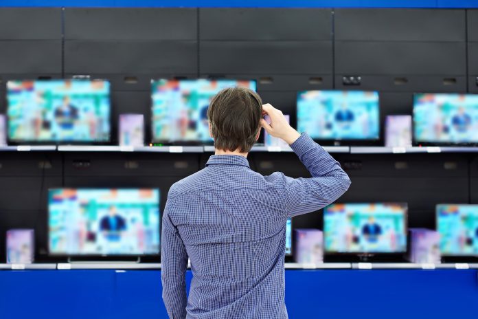 man looking at tvs when shopping