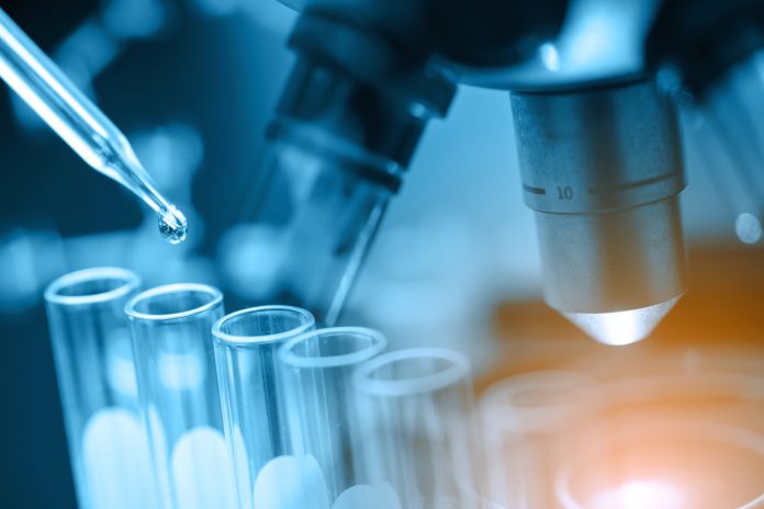 microscope with lab glassware, science laboratory research and development concept, representing HIV research and antiretroviral drugs