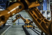 Robotic arms working on assembly line of appliance manufacturing factory.