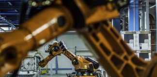 Robotic arms working on assembly line of appliance manufacturing factory.