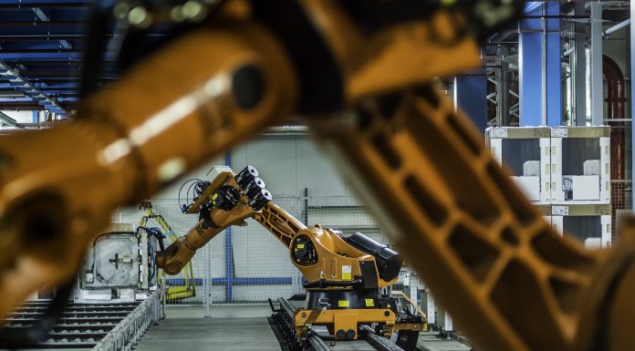 Robotic arms working on assembly line of appliance manufacturing factory.