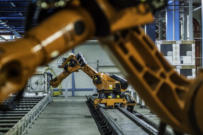 Robotic arms working on assembly line of appliance manufacturing factory.