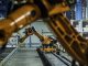 Robotic arms working on assembly line of appliance manufacturing factory.