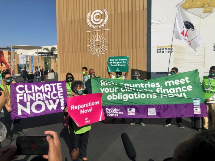 Climate activists emphasizing the urgency of climate finance at COP27