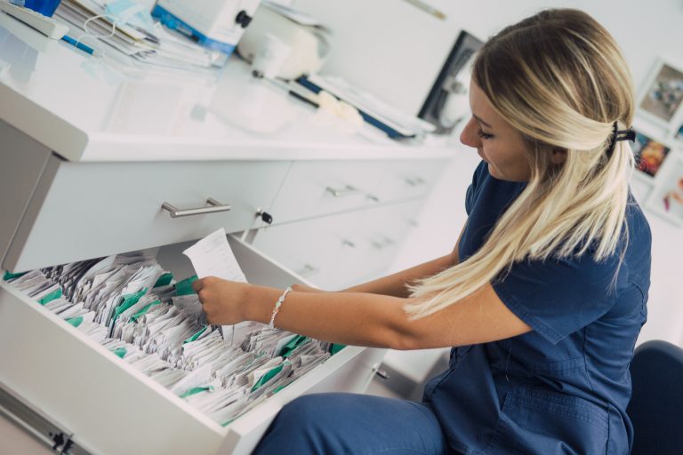 nhs nurse looking through patient files and data