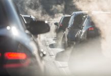 Moscow, Russia - August 08, 2017: Traffic jam. Blurred silhouettes of cars surrounded by steam from the exhaust pipes. Environmental pollution