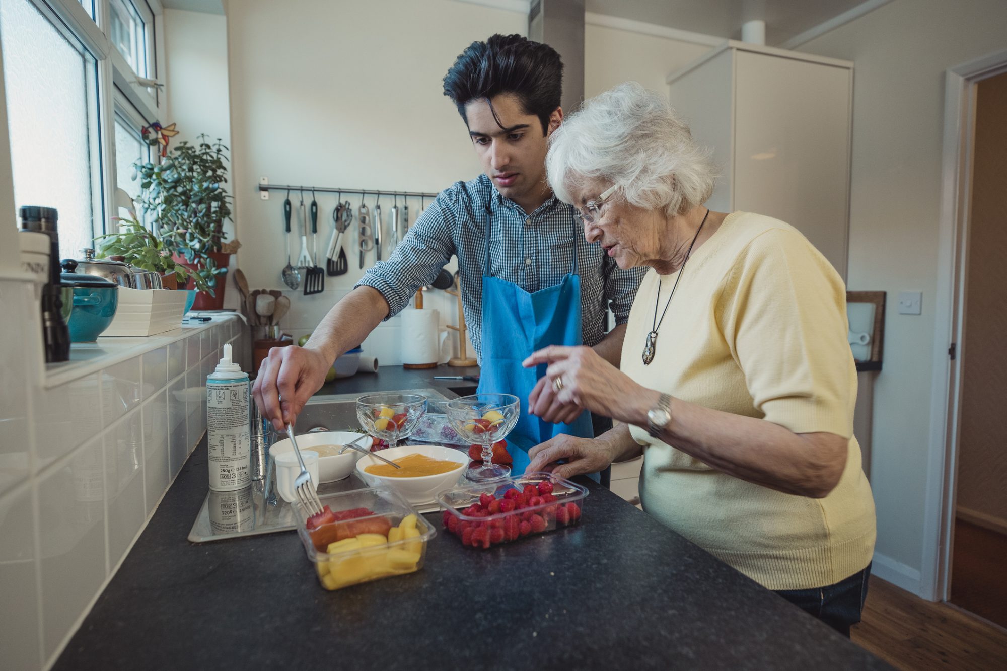 man helping a woman in the kitchen