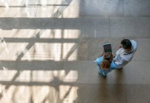 Female nurse showing something to doctor on tablet at the hospital - High angle view