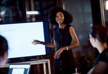 Shot of a young businesswoman delivering a presentation during a late night meeting at work