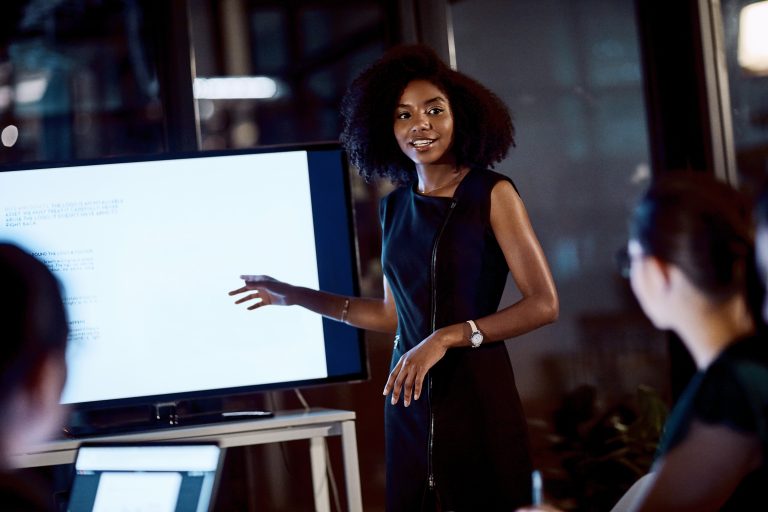 Shot of a young businesswoman delivering a presentation during a late night meeting at work