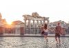 Young couple tourist walking pointing towards Roman Forum at sunrise. Historical imperial Foro Romano in Rome, Italy from panoramic point of view.