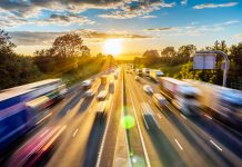 heavy traffic moving at speed on UK motorway in England at sunset.