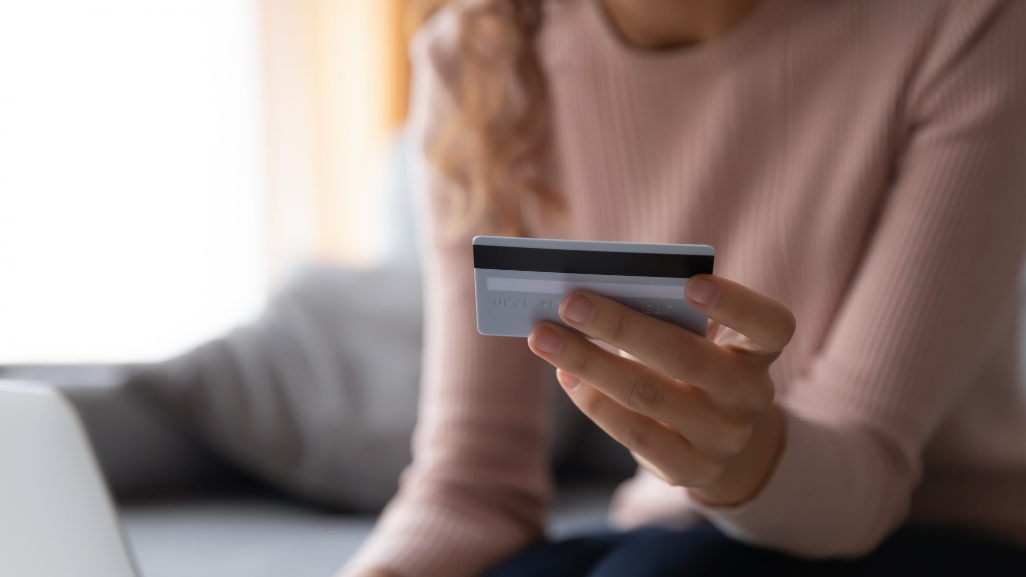 Close up woman paying online, holding plastic credit card, girl using banking service, shopping, ordering and buying in internet, making payment, checking balance, sitting on couch at home