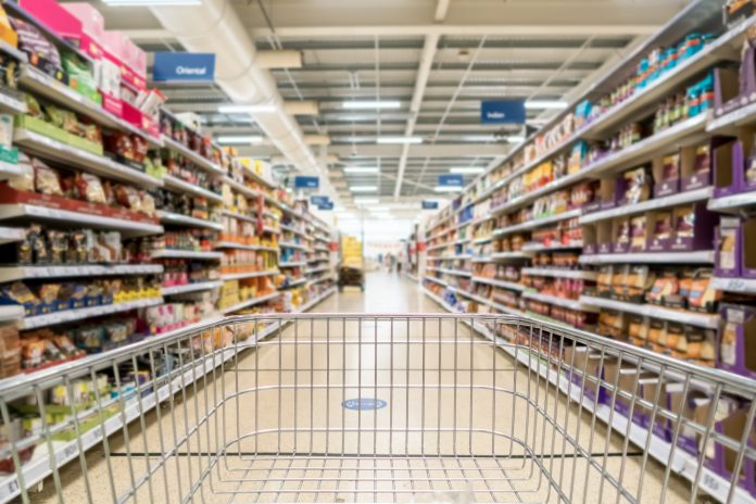 Unrecognizable supermarket aisle as background, an array of food - intimidating for those with eating disorders
