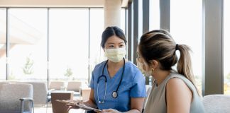 The mid adult female surgeon goes out to the waiting room to ask the young adult woman for information about the patient.