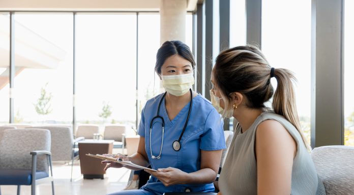 The mid adult female surgeon goes out to the waiting room to ask the young adult woman for information about the patient.