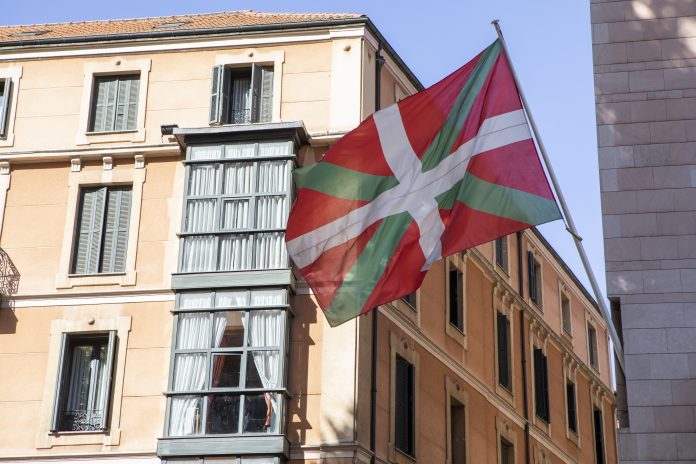 Bandera vasca fuera de un edificio antiguo en el centro de la ciudad de Bilbao