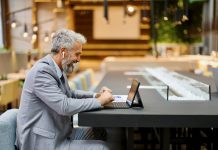 Businessman working in a lounge bar using digital tablet