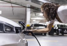 Woman refueling and charging an electric vehicle in a garage