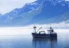 "Large fishing boat anchored in Valdez, Alaska bay. Chugach Mountains in background."