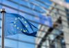 European Union flags in front of the blurred European Parliament in Brussels, Belgium